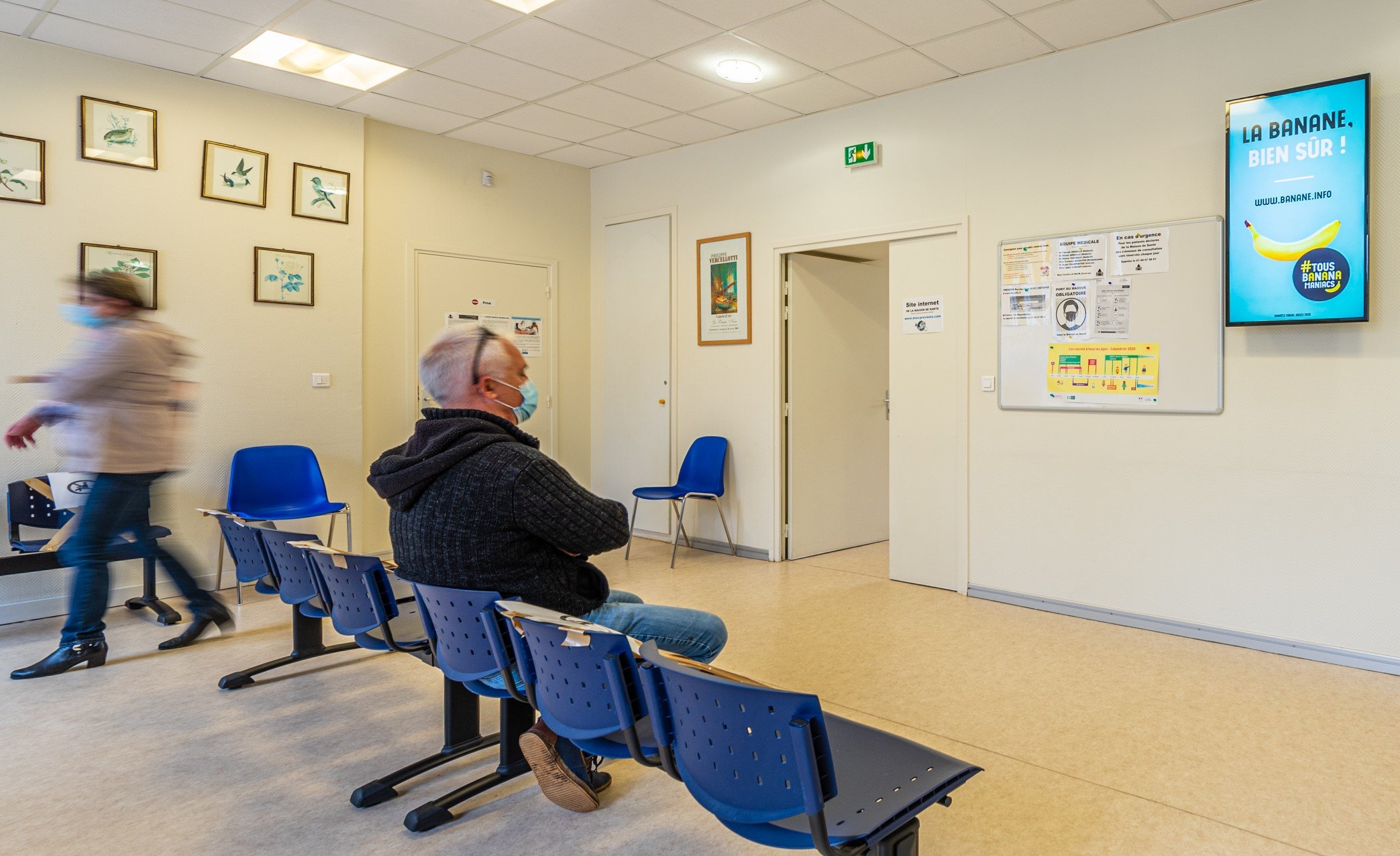 Patient regardant un écran d'affichage dynamique dans une salle d'attente médicale