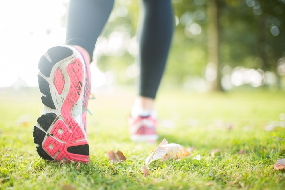 Close up picture of pink sole from running shoe in a park on a sunny day