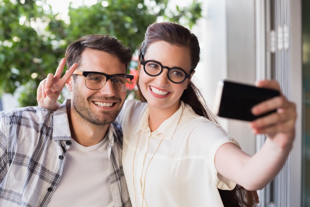 Cute couple on a date taking a selfie at the cafe