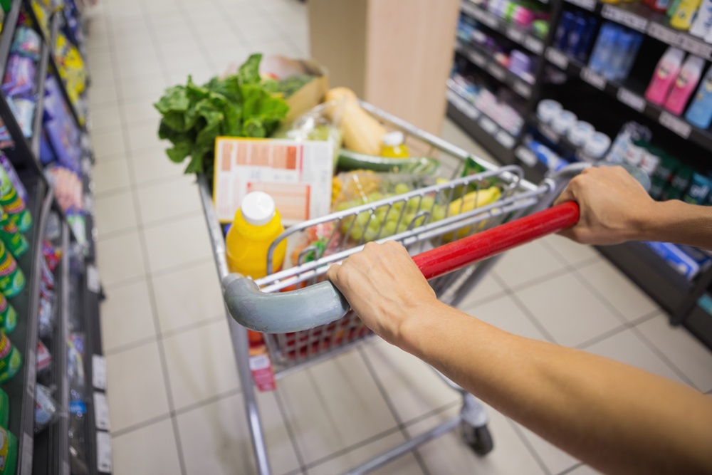 woman buy products with her trolley at supermarket.jpeg